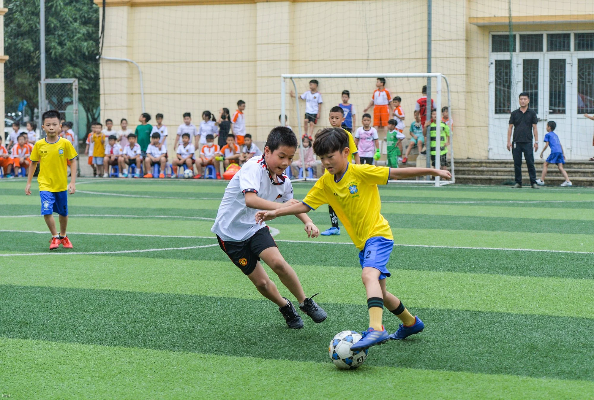 Học sinh cấp 2 thi đấu bóng đá sôi nổi trên sân cỏ