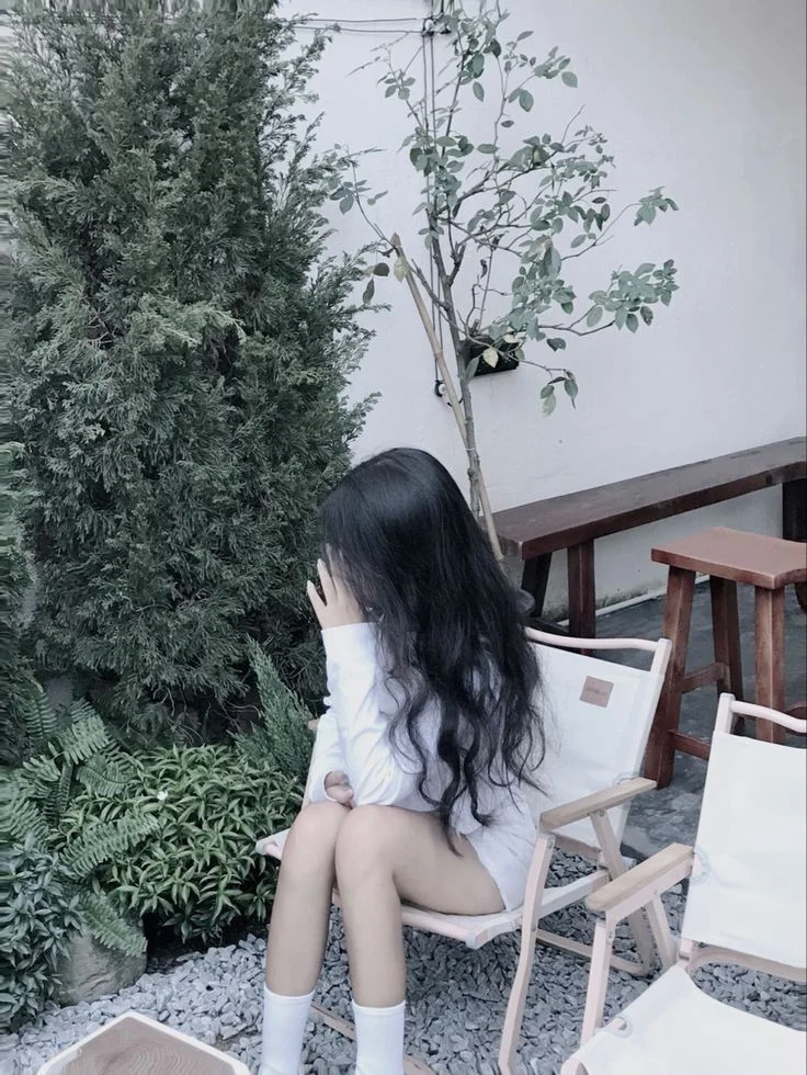 Ảnh pin nữ ngồi ghế gỗ ngoài trời