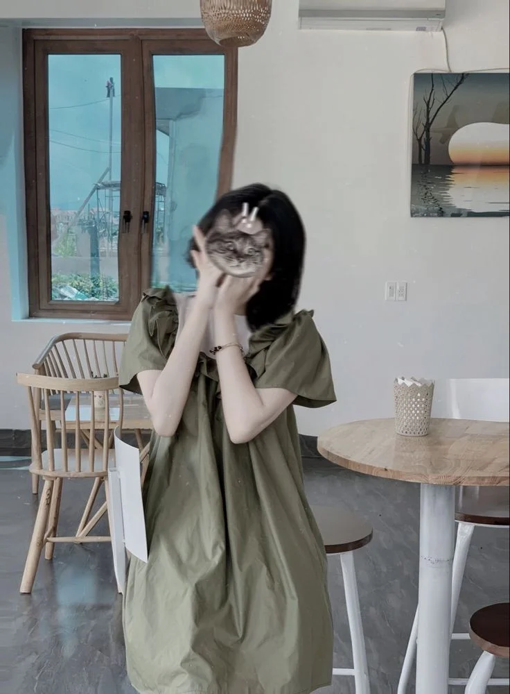 Ảnh pin nữ mặc váy xanh chụp ảnh trước gương