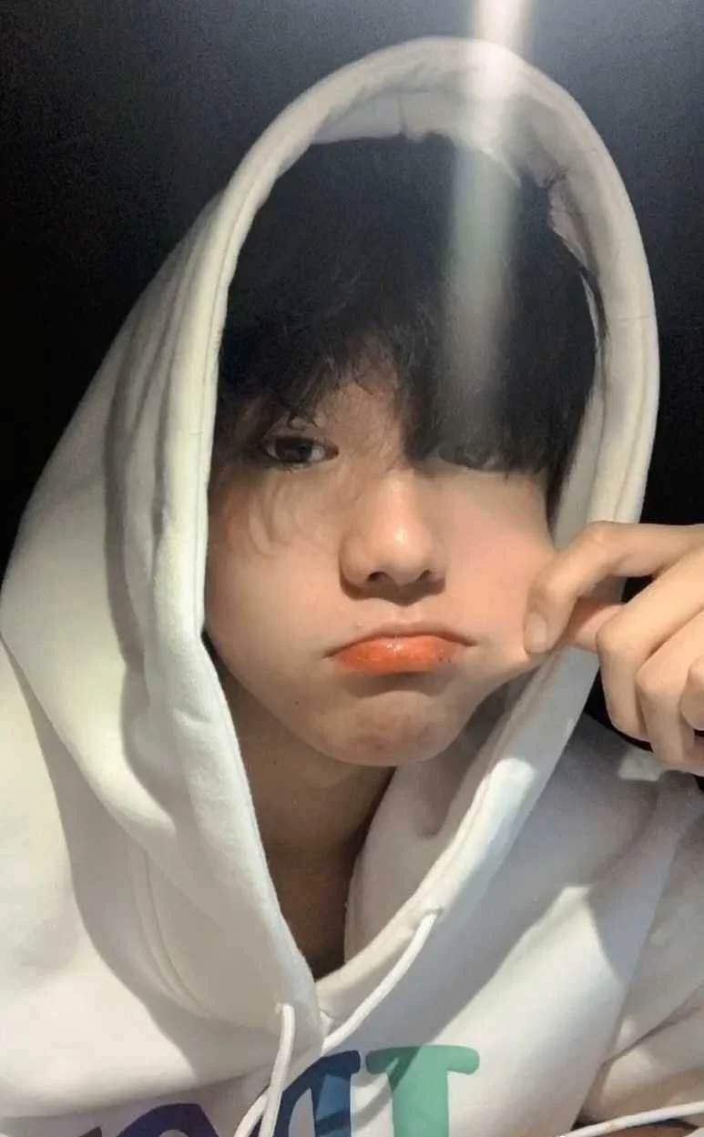 Chàng trai trẻ tạo dáng dễ thương trong chiếc áo hoodie trắng